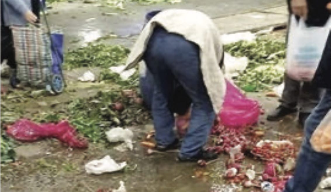 Çöplerin arasında yiyecek arayan insanlar